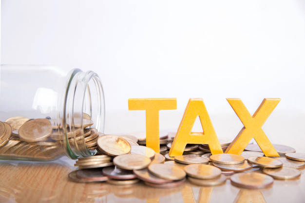 tax concept word tax put on coins and glass bottles with coins inside on white background - جرایم فرار مالیاتی